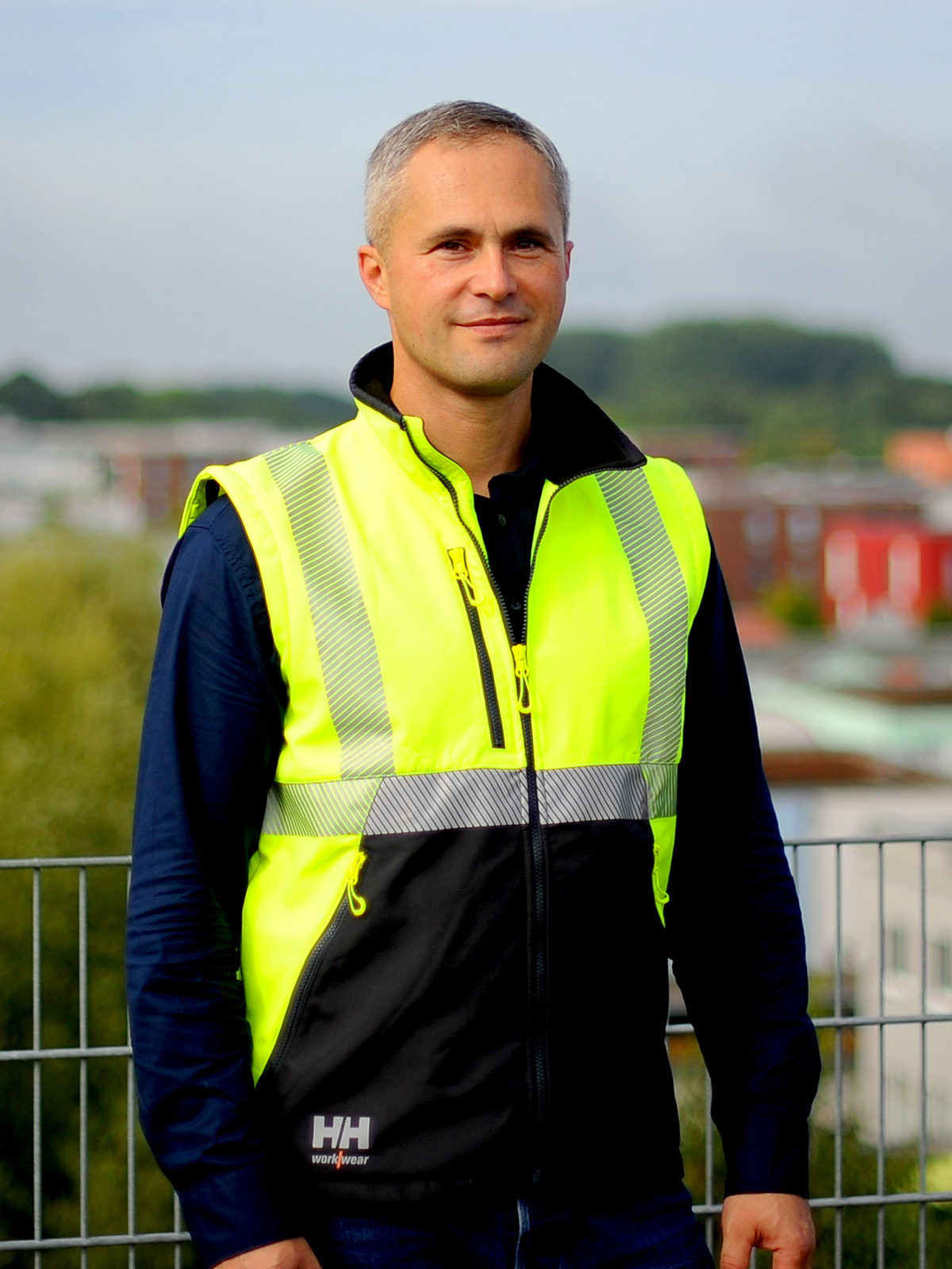 Sebastian Gode von SiGeKo Plus auf einer Baustelle mit Sicherheitsjacke